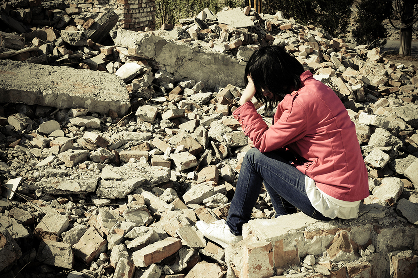 woman sitting in rubble